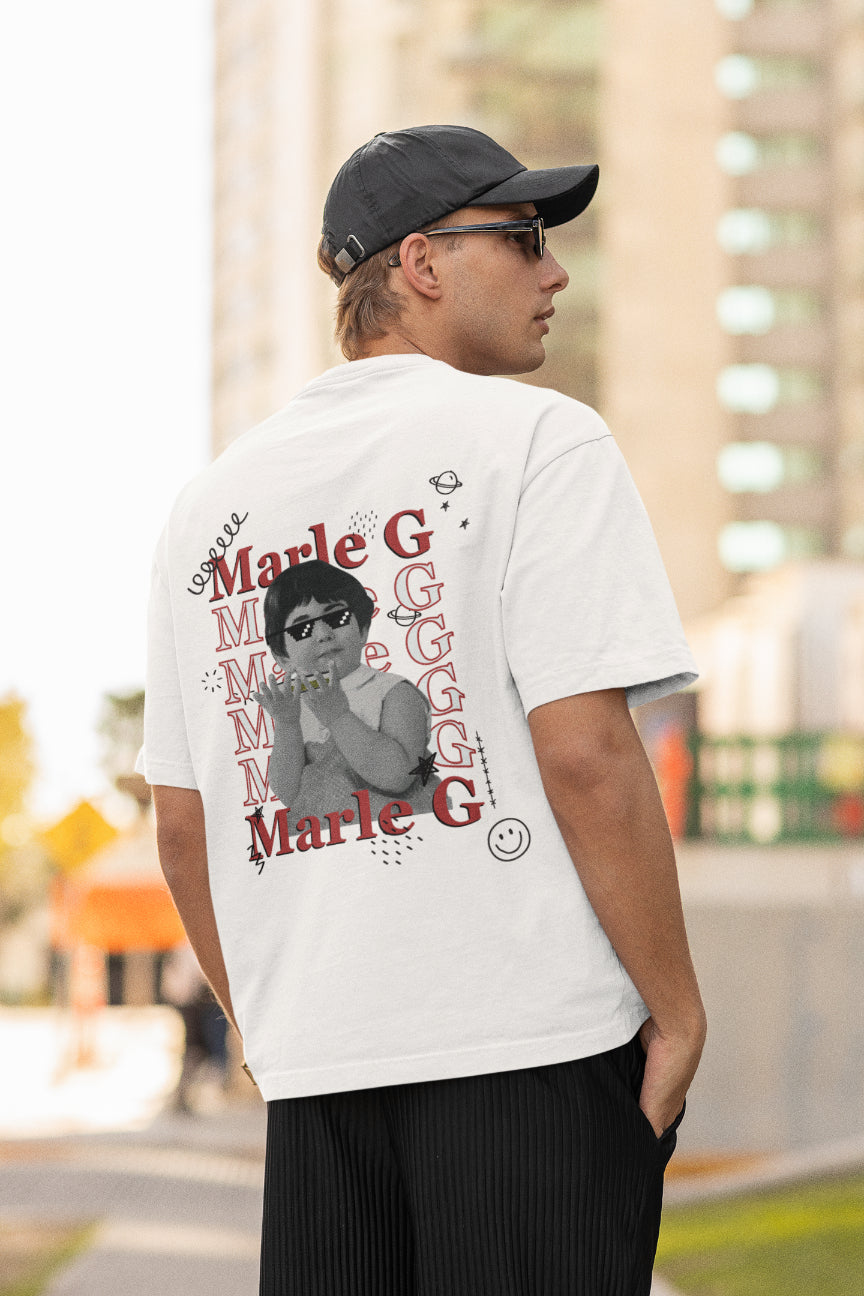 A model wearing a white oversized tshirt with the text "marle g", indian streetwear, desi designs, stoner wear